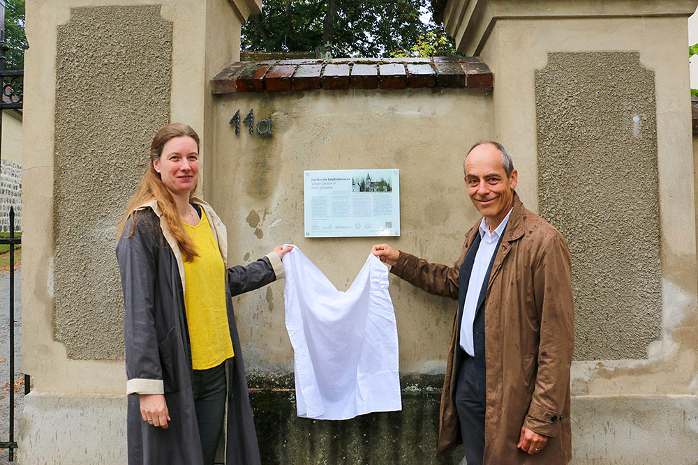 Pfarrerin G. Zachow und Ortsvorsteher W. Sträter (v.l.) bei der Enthüllung des Fontane-Schildes am Eingang der Groß Gienicker Dorfkirche